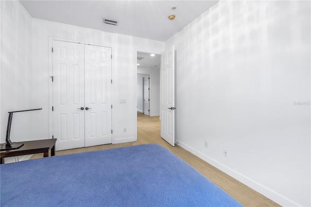 unfurnished bedroom featuring a closet and light wood-type flooring