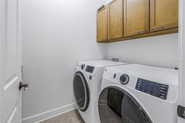 laundry room with washer and dryer and cabinets