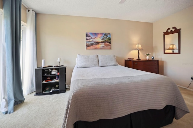 carpeted bedroom featuring ceiling fan and a textured ceiling