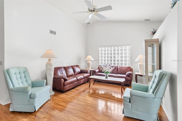 living room with wood-type flooring, high vaulted ceiling, and ceiling fan