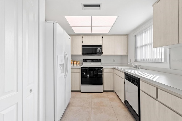 kitchen featuring sink, light tile patterned floors, and white appliances