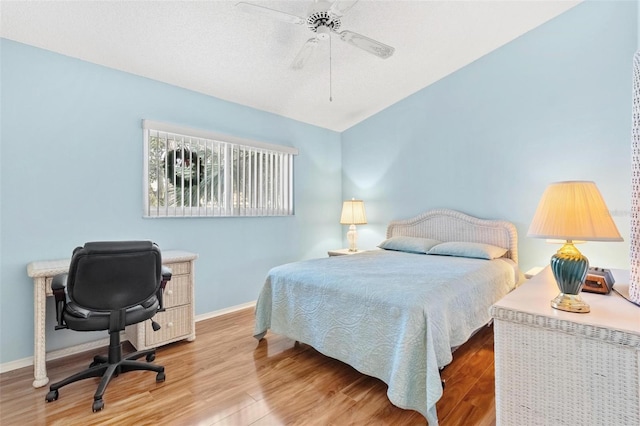 bedroom with hardwood / wood-style floors, vaulted ceiling, and ceiling fan