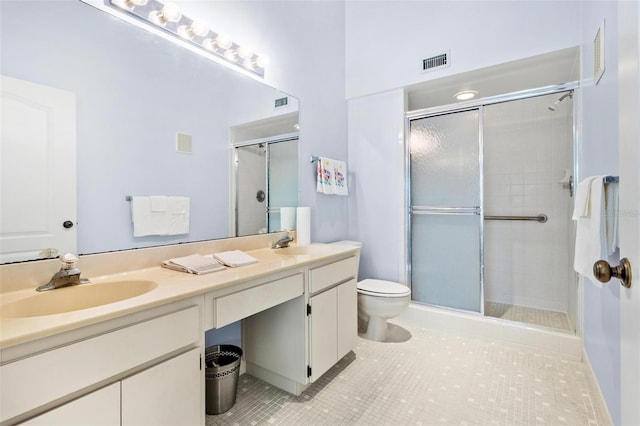 bathroom with tile patterned flooring, vanity, toilet, and a shower with door