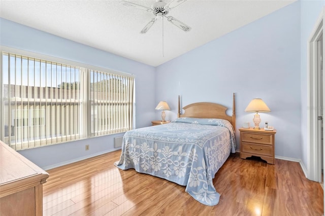 bedroom with hardwood / wood-style floors, a textured ceiling, and ceiling fan