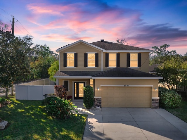 view of front of house featuring a garage and a yard