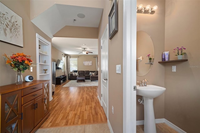 hallway featuring built in shelves and light hardwood / wood-style floors