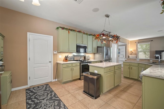 kitchen with appliances with stainless steel finishes, sink, light tile patterned floors, a center island, and green cabinets