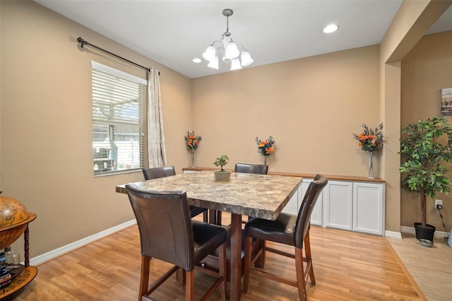 dining space featuring light wood-type flooring and a chandelier