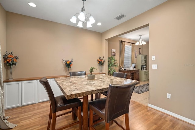 dining space featuring a chandelier and light wood-type flooring