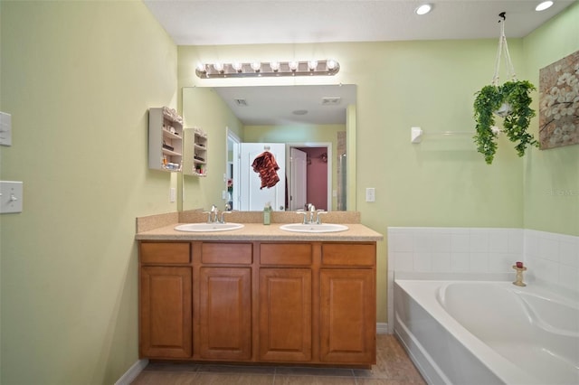 bathroom with tile patterned flooring, a bathtub, and vanity