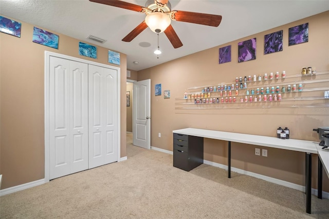 carpeted office featuring ceiling fan