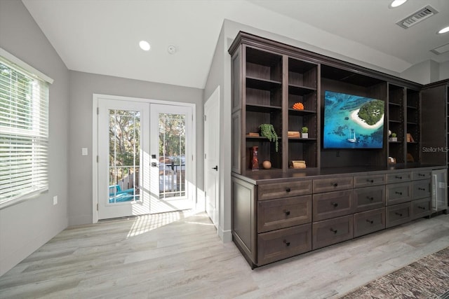 interior space with light hardwood / wood-style flooring, a healthy amount of sunlight, and vaulted ceiling