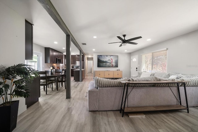 living room featuring ceiling fan and light hardwood / wood-style flooring