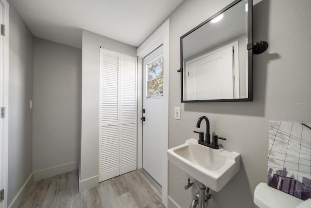 bathroom with wood-type flooring, toilet, and sink