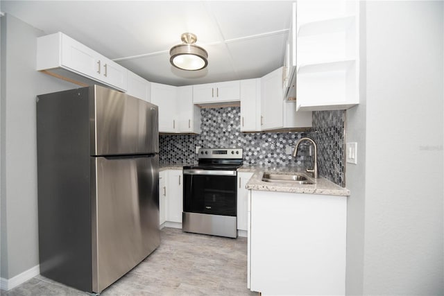 kitchen with tasteful backsplash, white cabinetry, sink, and stainless steel appliances