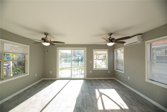 unfurnished room with wood-type flooring, a wall mounted AC, and ceiling fan