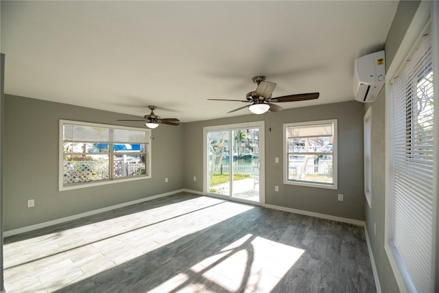 spare room featuring a wall mounted air conditioner, ceiling fan, and light wood-type flooring