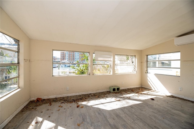 spare room with hardwood / wood-style floors, a healthy amount of sunlight, and lofted ceiling