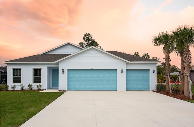 view of front of property featuring a garage and a lawn