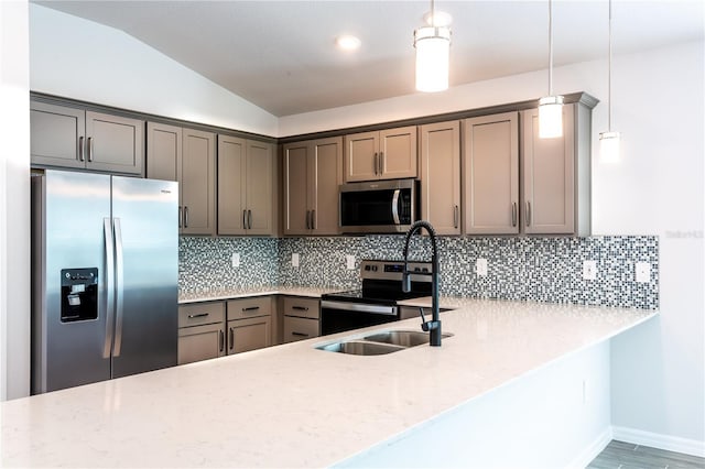 kitchen with backsplash, stainless steel appliances, pendant lighting, hardwood / wood-style flooring, and lofted ceiling