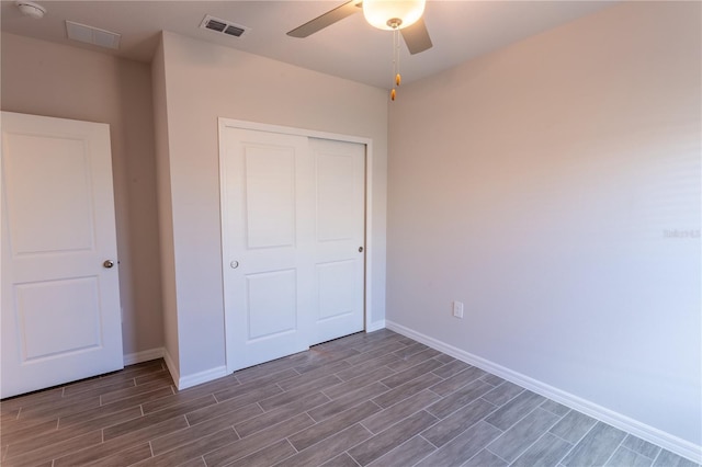 unfurnished bedroom with ceiling fan and a closet