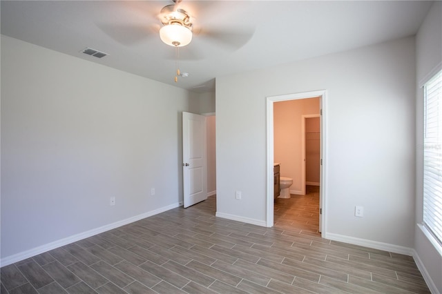 unfurnished bedroom featuring ensuite bath, ceiling fan, and light hardwood / wood-style flooring