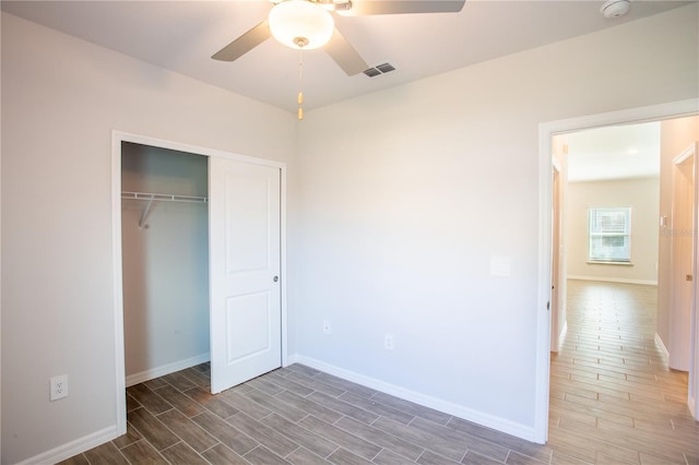 unfurnished bedroom with ceiling fan, dark hardwood / wood-style flooring, and a closet