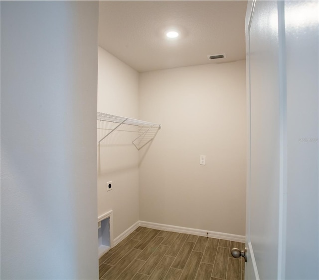 laundry room with electric dryer hookup and dark hardwood / wood-style flooring