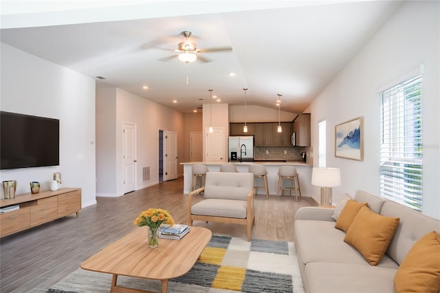 living room featuring wood-type flooring, ceiling fan, and lofted ceiling