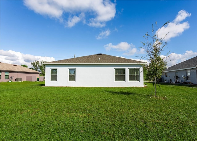 back of property with cooling unit and a yard