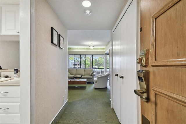 hallway featuring dark colored carpet