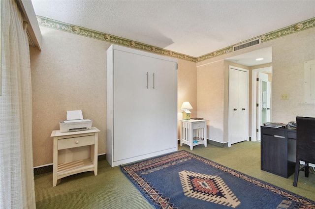 home office with dark colored carpet and a textured ceiling