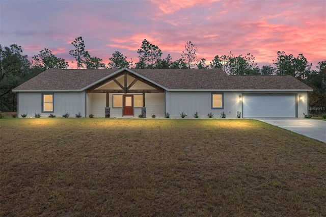 ranch-style house featuring a yard and a garage