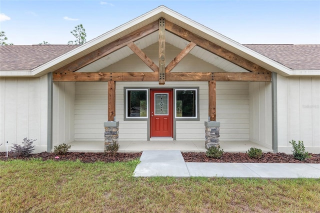 doorway to property featuring a yard and a porch