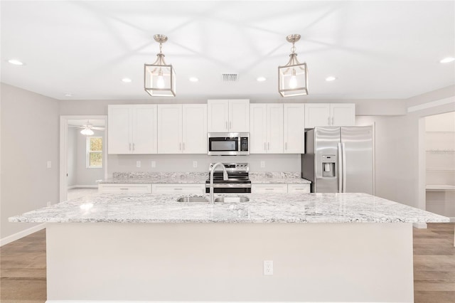 5421 N Nakoma Dr, Beverly Hills, FL 34465 - kitchen featuring stainless steel appliances, recessed lighting, light wood finished floors, a kitchen island with sink, and white cabinets