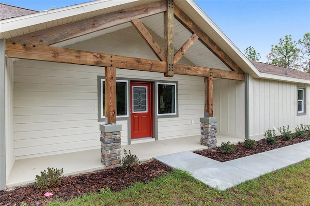 view of exterior entry featuring covered porch