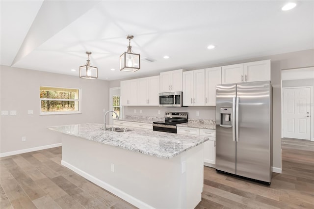 kitchen featuring white cabinetry, an island with sink, light hardwood / wood-style floors, and appliances with stainless steel finishes