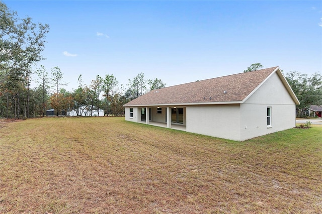 rear view of house featuring a patio and a lawn