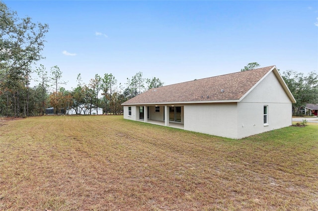 5421 N Nakoma Dr, Beverly Hills, FL 34465 - back of property featuring stucco siding, a yard, a patio, and roof with shingles
