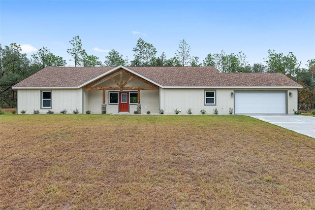 single story home with covered porch, a garage, and a front lawn