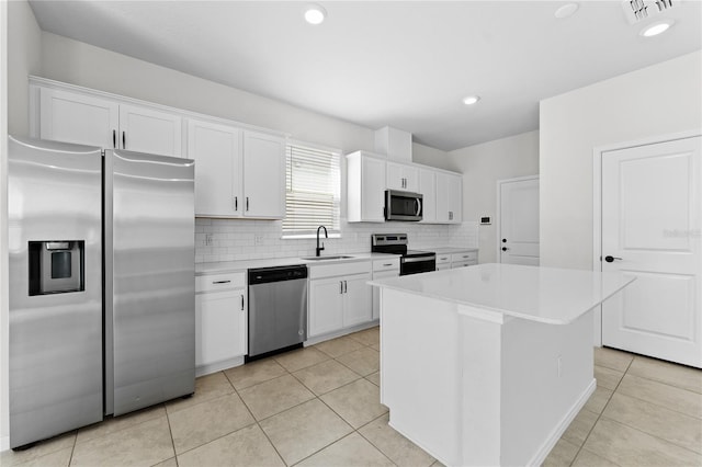 kitchen with a kitchen island, sink, white cabinetry, and stainless steel appliances