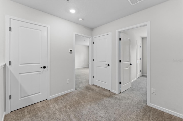 hallway featuring light colored carpet