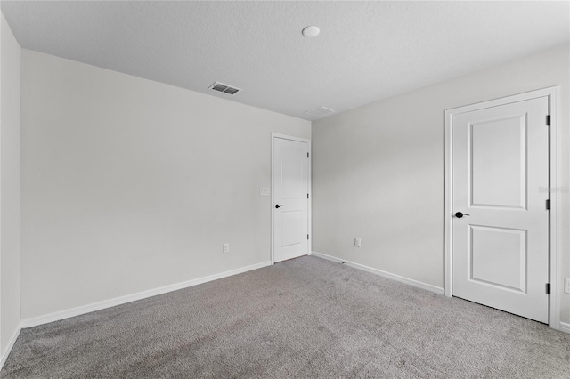 empty room featuring a textured ceiling and carpet floors