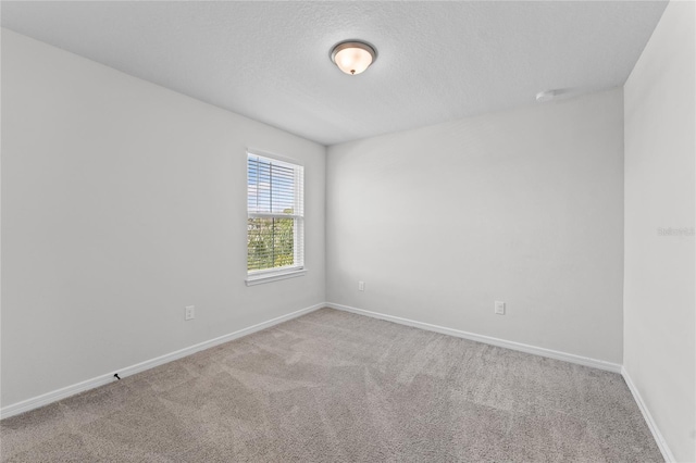 carpeted spare room featuring a textured ceiling