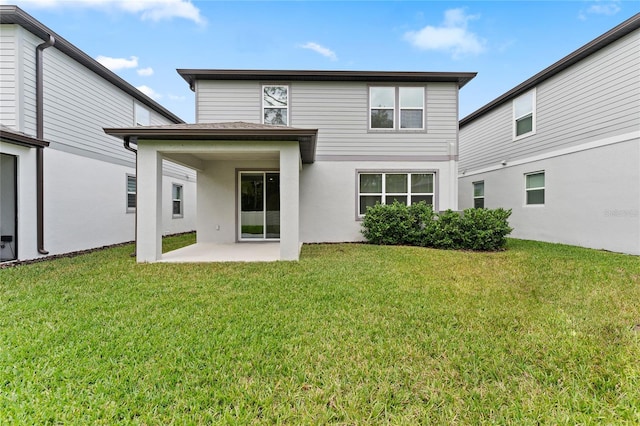 rear view of property with a yard and a patio