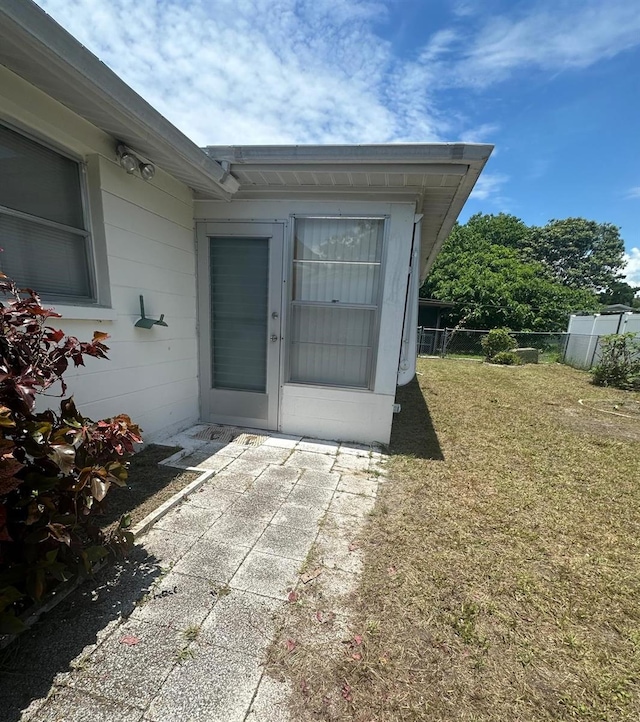 doorway to property with a lawn