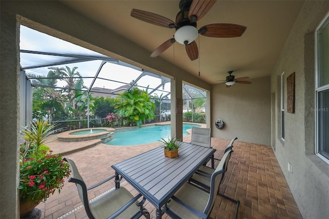 view of patio featuring ceiling fan, a swimming pool with hot tub, and glass enclosure