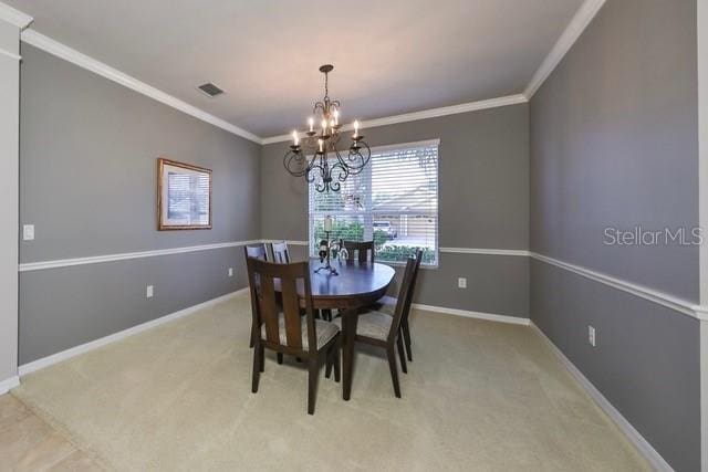 dining area with a chandelier, light colored carpet, and ornamental molding