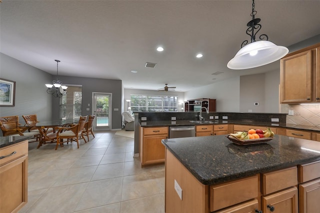 kitchen featuring ceiling fan with notable chandelier, sink, decorative light fixtures, dishwasher, and an island with sink