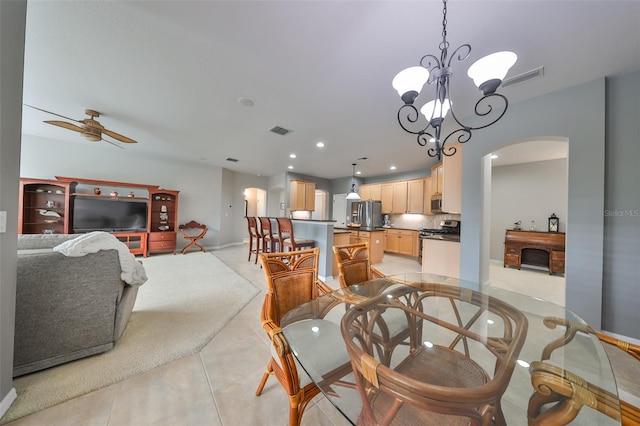 dining space with ceiling fan with notable chandelier and light tile patterned floors